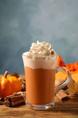 Ahşap masada lezzetli balkabaklı latte ve tarçın, yakın plan.