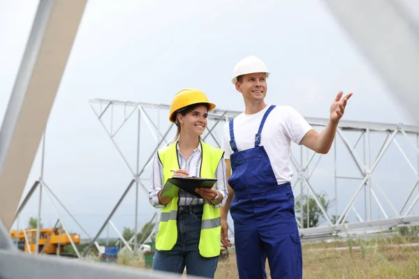 Professional engineers working on installation of electrical substation outdoors