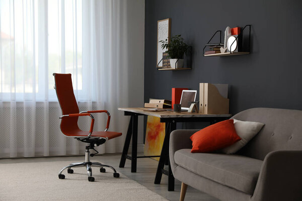 Modern workplace with comfortable chair in stylish home office interior