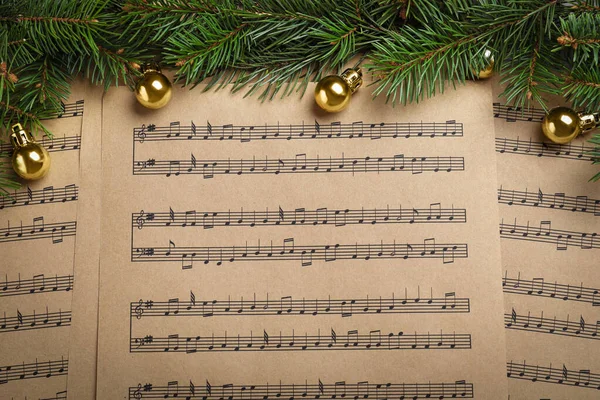 圣诞乐谱上的冷杉枝和金球 — 图库照片