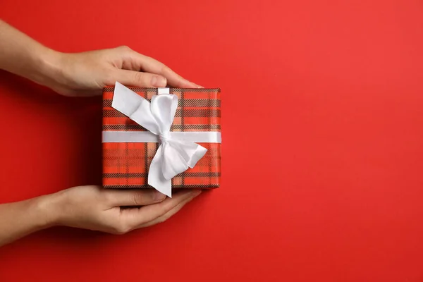 Kezében Karácsonyi Ajándék Piros Háttérrel Felülnézetből Szöveg Helye — Stock Fotó