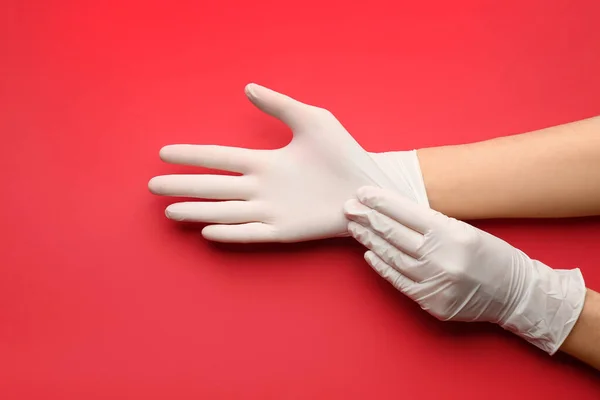 Πρόσωπο Που Φοράει Ιατρικά Γάντια Κόκκινο Φόντο Closeup Των Χεριών — Φωτογραφία Αρχείου