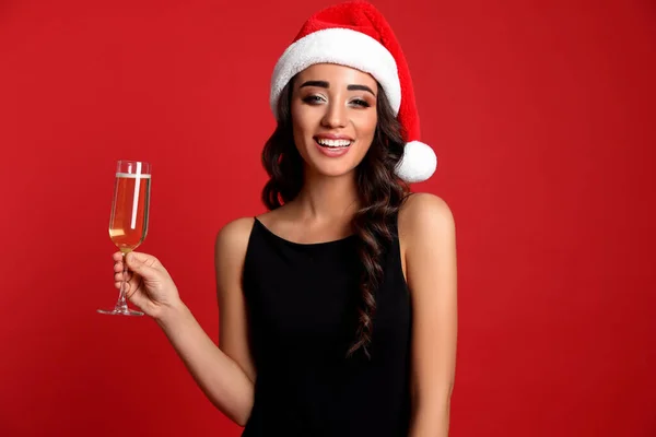 Noel Baba Şapkalı Güzel Bir Kadın Kırmızı Arka Planda Bir — Stok fotoğraf