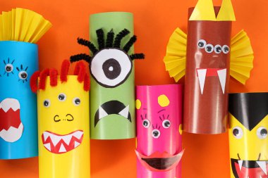 Turuncu arka planda komik canavarlar, düz yatıyorlar. Cadılar Bayramı dekorasyonu