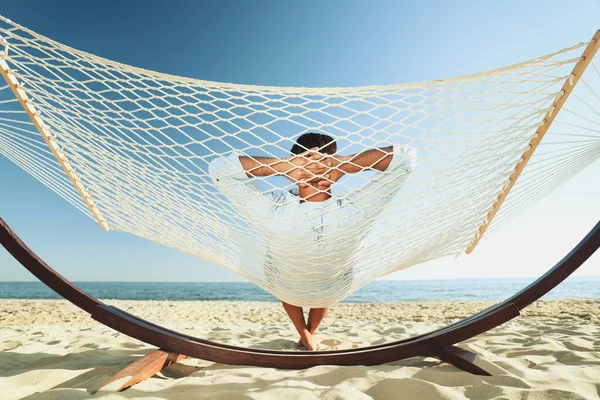 男人在海滩上的吊床上放松 — 图库照片
