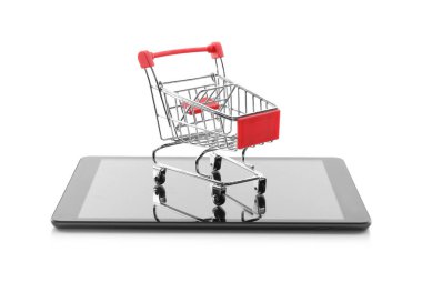 İnternet alışverişi. Beyaz arka planda küçük el arabası ve modern tablet