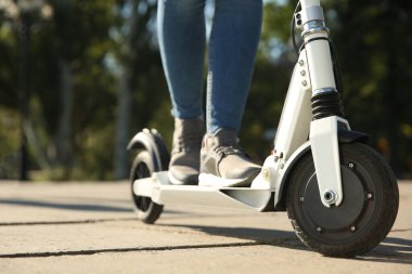 Dışarıda elektrikli scooter kullanan bir kadın, yakın plan.