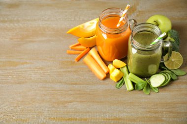 Lezzetli sebze suları ve ahşap masada taze malzemeler. Metin için boşluk