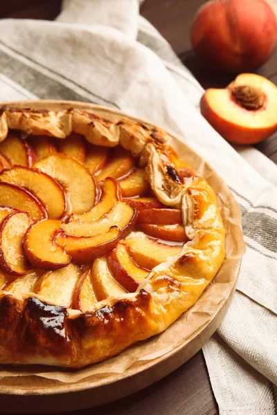 Delicious juicy peach pie on wooden table