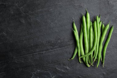 Siyah masada taze yeşil fasulye, düz uzanmış. Metin için boşluk