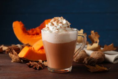 Lezzetli balkabaklı latte ve kahverengi ahşap masa malzemeleri, yakın plan.