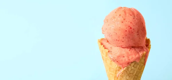 色泽浅蓝色背景的华夫饼锥中美味的粉红色冰淇淋 案文的篇幅 — 图库照片