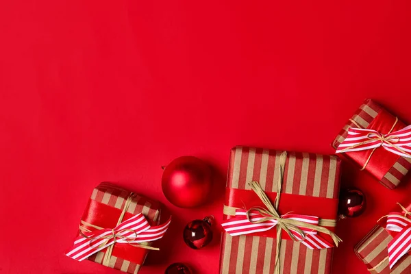 Parlak Kırmızı Arka Planda Noel Topları Olan Hediye Kutuları Düz — Stok fotoğraf