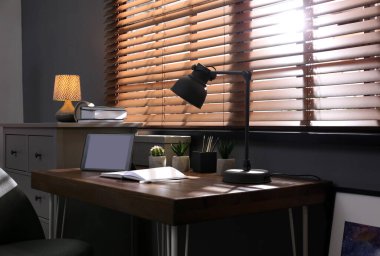 Pencerenin yanında rahat işyeri olan şık bir oda.