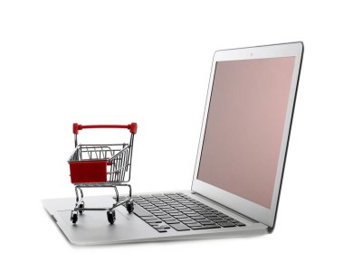 İnternet alışverişi. Küçük arabalı dizüstü bilgisayar beyaza izole edilmiş.