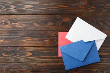 Ahşap zemin üzerinde renkli kağıt zarflar, düz bir zemin. Metin için boşluk