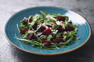 Gri masada taze, lezzetli pancar salatası, yakın plan.