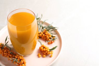 Lezzetli deniz dikeni suyu ve açık gri mermer masada taze böğürtlen, yakın plan. Metin için boşluk