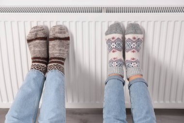 Isıtma kaloriferinde ısınan bacaklar, yakın plan.