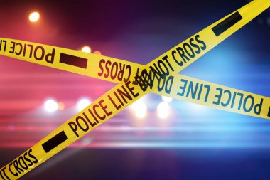 Sarı emniyet şeridi olay yerini izole ediyor. Şehir caddesinin bulanık görüntüsü, kırmızı ve mavi polis arabası ışıkları.