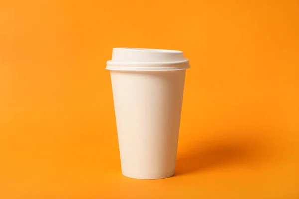 オレンジを背景にしたテイクアウト用のコーヒーカップ クローズアップ — ストック写真