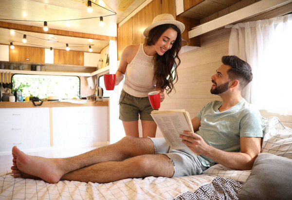 Happy young couple spending time together in trailer. Camping vacation