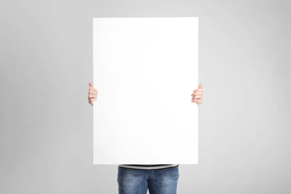 Man Holding Blank Poster Light Grey Background — Stock Photo, Image