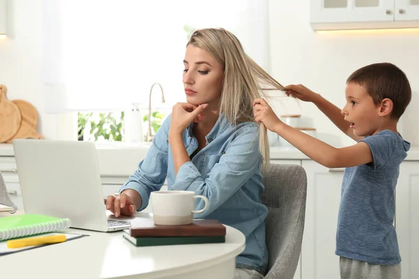 Niño Pequeño Tirando Del Pelo Madre Mientras Ella Trata Trabajar — Foto de Stock