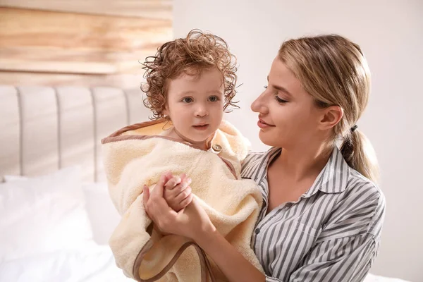 Mama Gospodarstwa Cute Little Baby Zawinięte Kapturze Ręcznik Kąpieli Pomieszczeniach — Zdjęcie stockowe