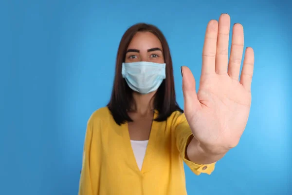 Young Woman Protective Mask Showing Stop Gesture Light Blue Background — Stock Photo, Image