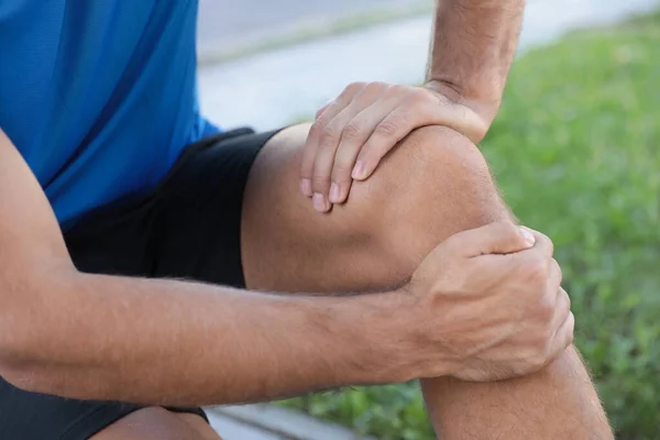 スポーツウェアの男は膝の問題を屋外で クローズアップしている — ストック写真