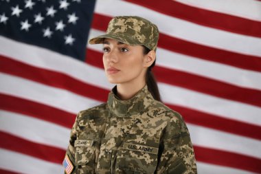 Arka planda ABD bayrağı olan bayan Amerikan askeri. Askerlik.