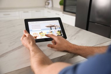 Tablet 'ten online bilet ayırtan adam, yakın plan. Seyahat acentası kavramı