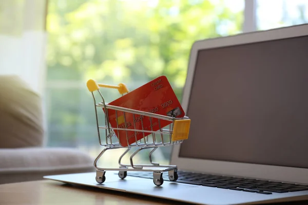 Einkaufen Internet Laptop Und Kleiner Einkaufswagen Mit Kreditkarte Auf Tisch — Stockfoto