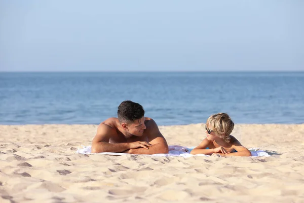 Padre Hijo Tumbados Playa Arena Cerca Del Mar Vacaciones Verano —  Fotos de Stock