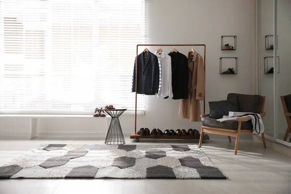 Dressing room interior with clothing rack and armchair