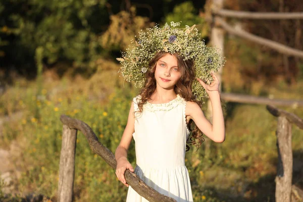 Симпатична Маленька Дівчинка Вінку Красивих Квітів Біля Дерев Яного Паркану — стокове фото