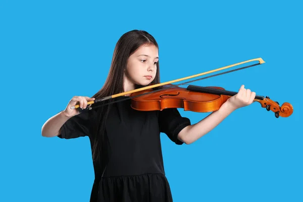 少女在浅蓝色背景下拉小提琴 — 图库照片