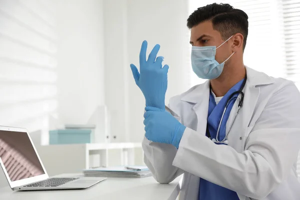 Médico Máscara Protectora Poniéndose Guantes Médicos Mesa Consultorio — Foto de Stock