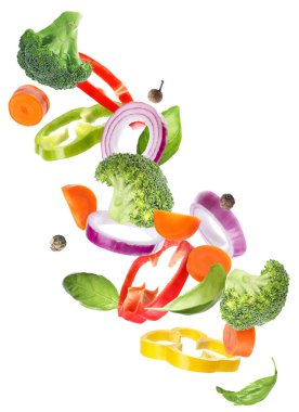 Beyaz arka plana düşen farklı taze sebze ve baharatlar.