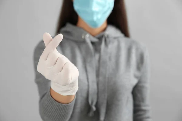 灰色の背景に対する韓国の心のジェスチャーを示す保護顔のマスクと医療手袋の女性 手に焦点を当て — ストック写真