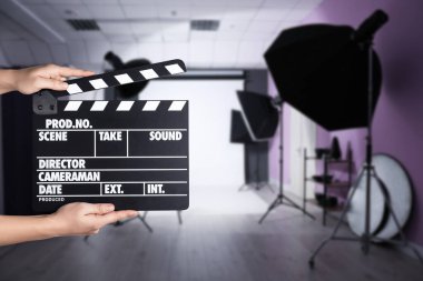 Asistan çekim yeri için el çırpma tahtası tutuyor, yakın çekim. Sinema yapımı 