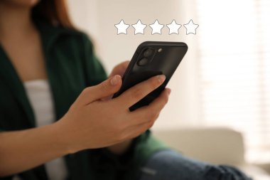 İncelemeyi akıllı telefondan yapan kadın, kapatıyor. Alet üstünde beş yıldız.
