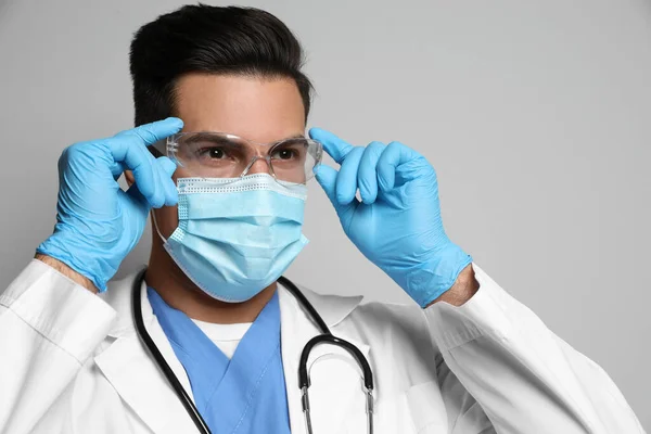 Dokter Beschermend Masker Bril Medische Handschoenen Tegen Lichtgrijze Achtergrond — Stockfoto