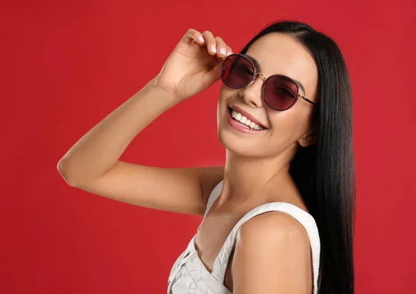 Hermosa Mujer Con Gafas Sol Sobre Fondo Rojo —  Fotos de Stock