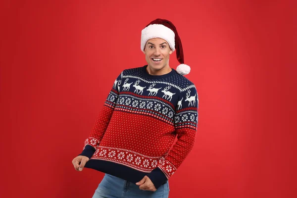 Happy Man Santa Hat Showing His Christmas Sweater Red Background — Stock Photo, Image