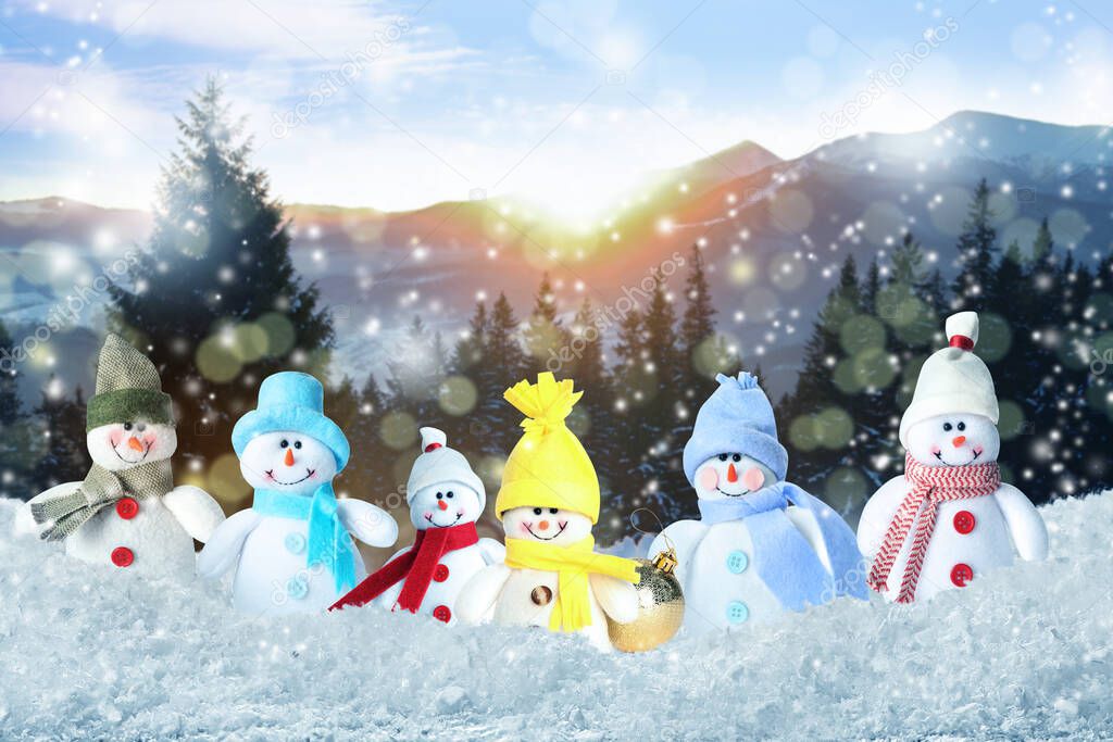 Cute toy snowmen in winter forest, bokeh effect