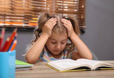 Masadaki yorgun küçük kız. Ödev yapıyorum.