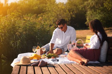 Mutlu çift piknikte iskelede vakit geçiriyor.