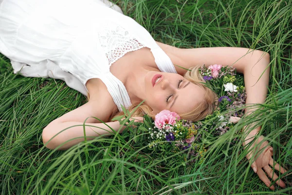 在绿草上戴花环的年轻女子 — 图库照片